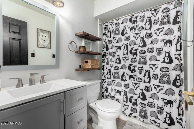 bathroom featuring toilet, curtained shower, and vanity