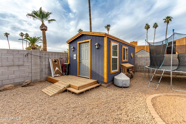 view of shed featuring a fenced backyard and a trampoline