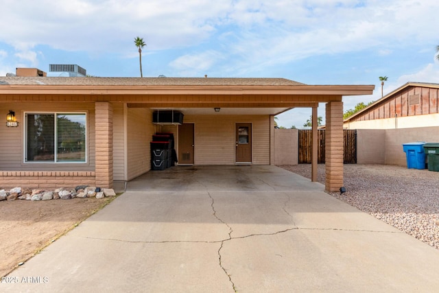 single story home featuring fence, an attached carport, and concrete driveway