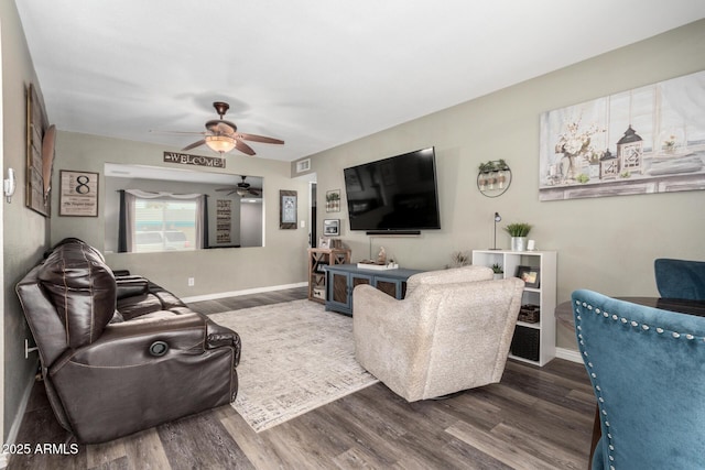 living area featuring baseboards, visible vents, and wood finished floors