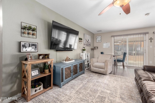 living area featuring a healthy amount of sunlight, ceiling fan, visible vents, and wood finished floors