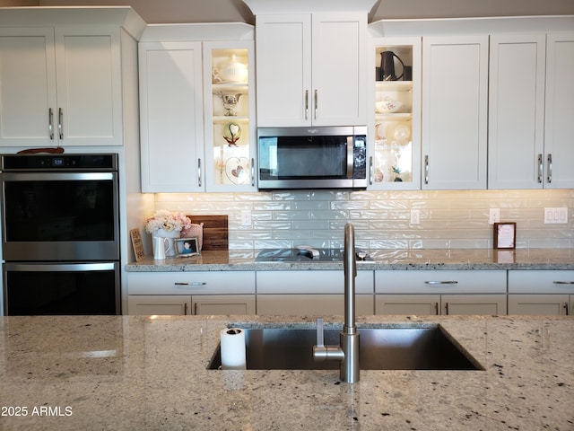 kitchen with white cabinets, glass insert cabinets, and stainless steel appliances