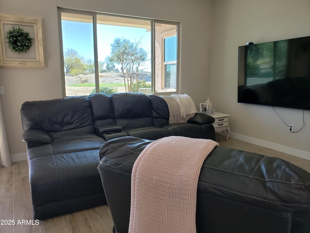 living area with baseboards and light wood finished floors