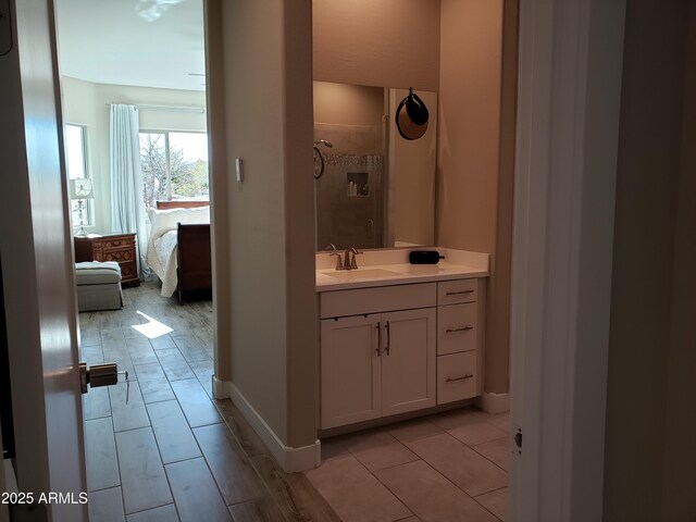 full bath with vanity, baseboards, and ensuite bathroom