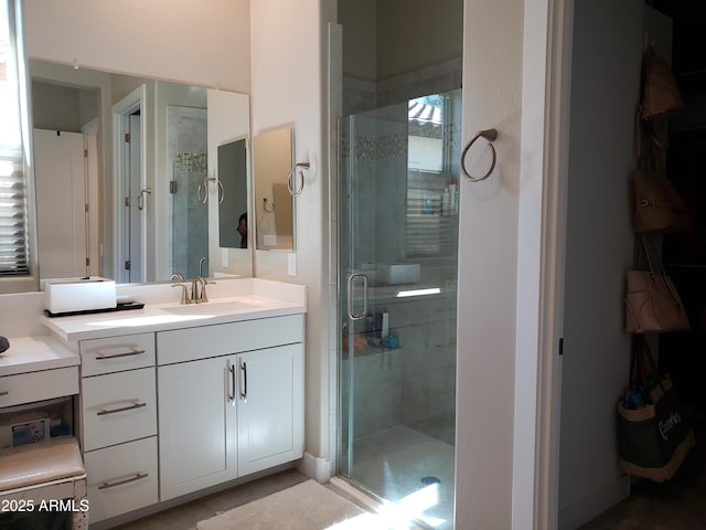 bathroom with a shower stall and vanity