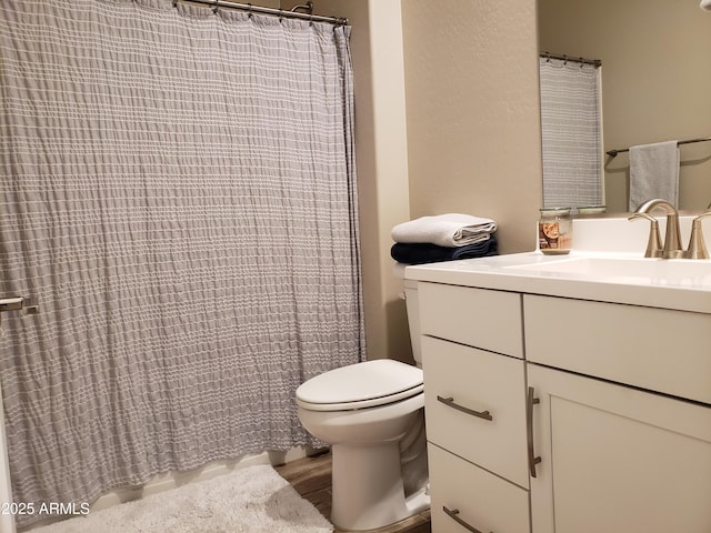 bathroom featuring a shower with shower curtain, vanity, toilet, and wood finished floors