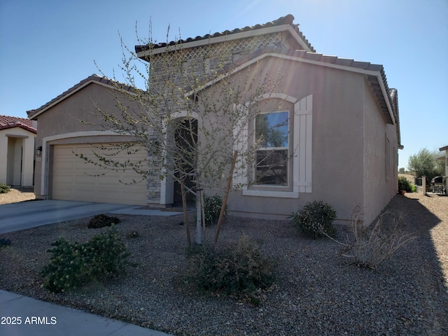 mediterranean / spanish home with a garage, driveway, a tile roof, and stucco siding