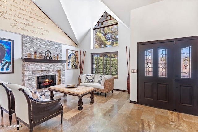 foyer with a stone fireplace and high vaulted ceiling