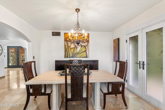 dining space with an inviting chandelier and french doors