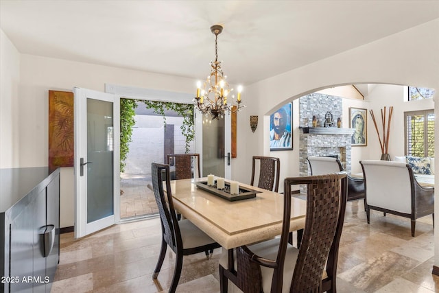 dining room featuring an inviting chandelier and a fireplace