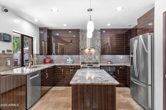 kitchen with light stone counters, hanging light fixtures, stainless steel appliances, and a center island