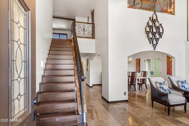 stairs featuring french doors and a high ceiling