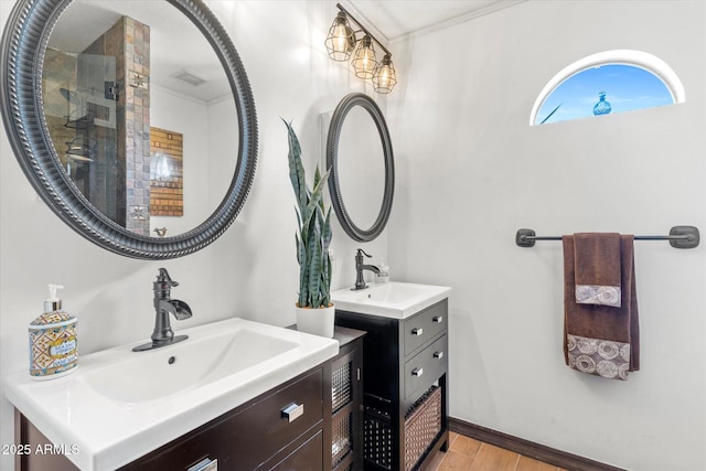 bathroom featuring hardwood / wood-style flooring, ornamental molding, and vanity