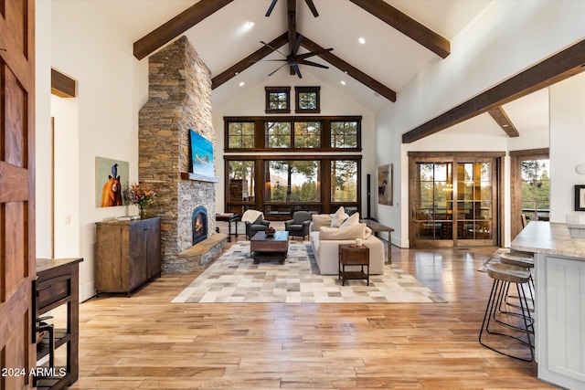 living room featuring beam ceiling, ceiling fan, high vaulted ceiling, and light wood-type flooring