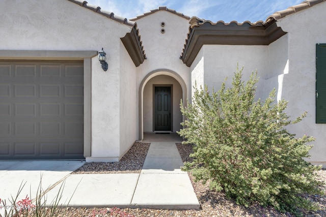 9723 W Patrick Ln, Peoria, AZ 85383 - doorway to property featuring stucco siding, a garage, and a tiled roof