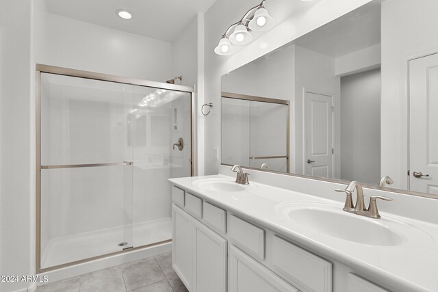 bathroom featuring vanity, tile patterned floors, and a shower with door