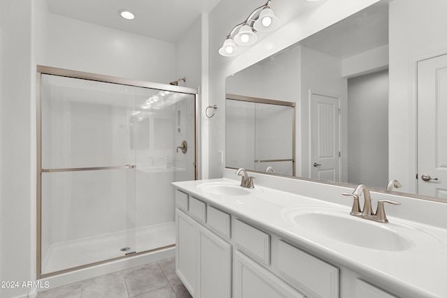 bathroom with double vanity, a sink, and a shower stall