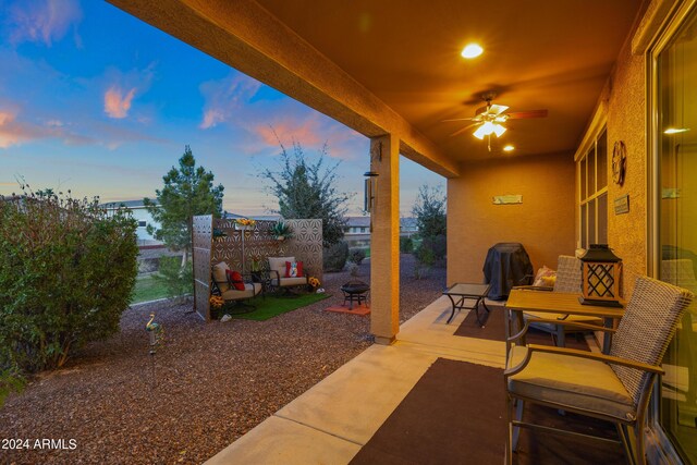 back house at dusk with an outdoor living space, a patio, and ceiling fan