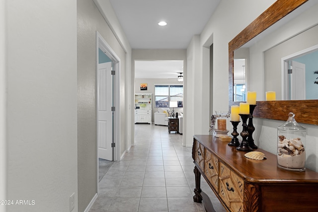 corridor with recessed lighting, baseboards, and light tile patterned floors