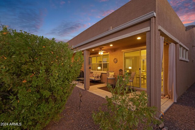 back of house with a patio and an outdoor living space with a fire pit