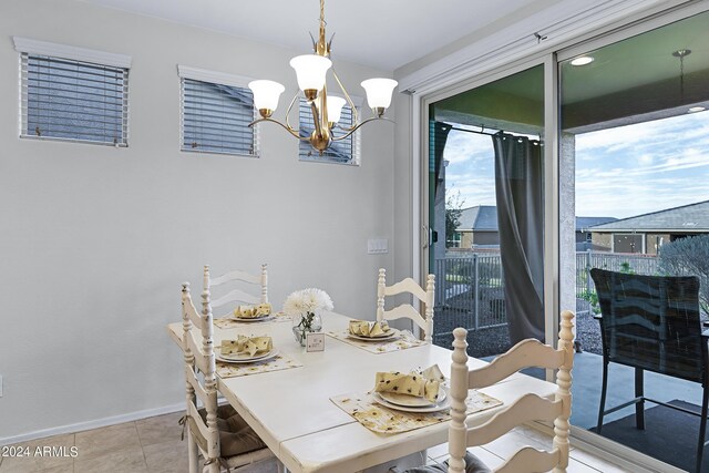 dining space with light tile patterned floors and a chandelier