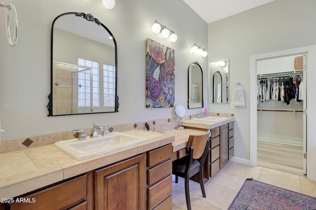 bathroom with a shower with door, tile patterned floors, and vanity