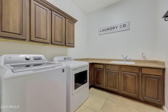 clothes washing area with sink, light tile patterned floors, cabinets, and separate washer and dryer