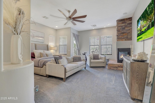 bedroom featuring ceiling fan, a fireplace, and carpet flooring