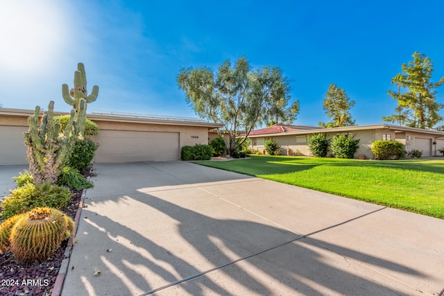 single story home featuring a garage and a front yard