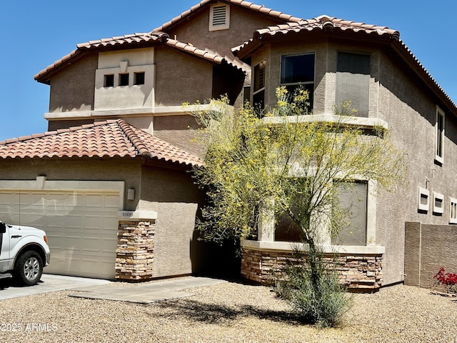 10489 S 182nd Dr, Goodyear, AZ 85338 - mediterranean / spanish-style home featuring an attached garage, driveway, stucco siding, and a tile roof