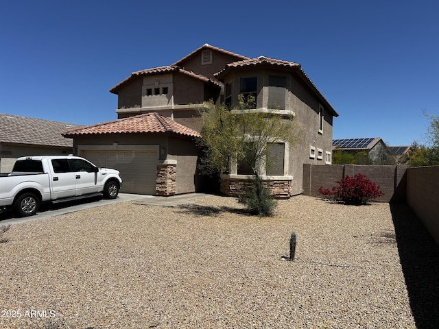 10489 S 182nd Dr, Goodyear, AZ 85338 - view of front of house with stucco siding, stone siding, an attached garage, a tile roof, and fence