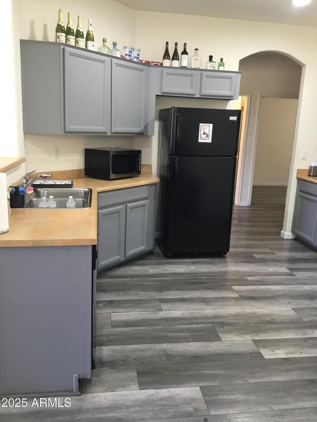 10489 S 182nd Dr, Goodyear, AZ 85338 - kitchen with gray cabinetry, freestanding refrigerator, a sink, and arched walkways