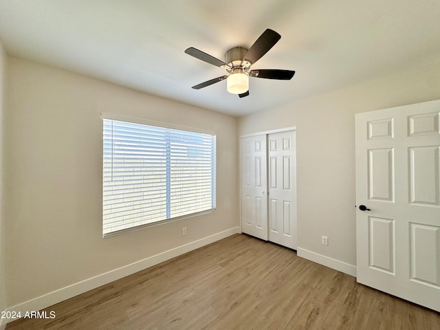 unfurnished bedroom with light hardwood / wood-style floors, a closet, and ceiling fan