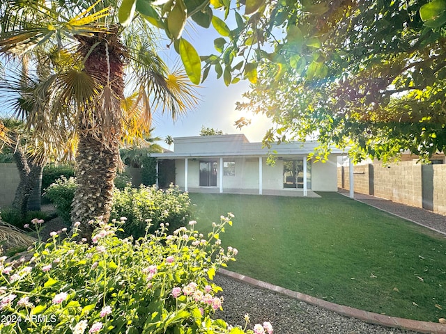 rear view of house featuring a lawn