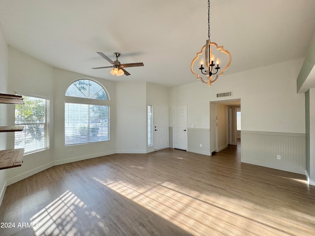 unfurnished living room featuring light wood-type flooring and ceiling fan with notable chandelier