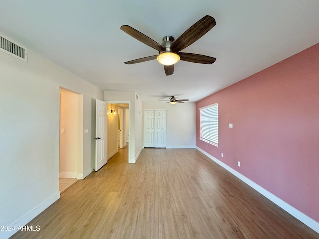 unfurnished bedroom featuring light hardwood / wood-style floors, a closet, and ceiling fan