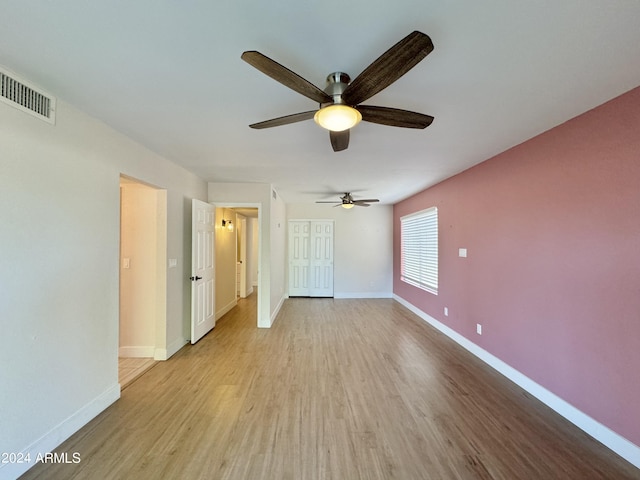 unfurnished bedroom with ceiling fan, light hardwood / wood-style flooring, and a closet