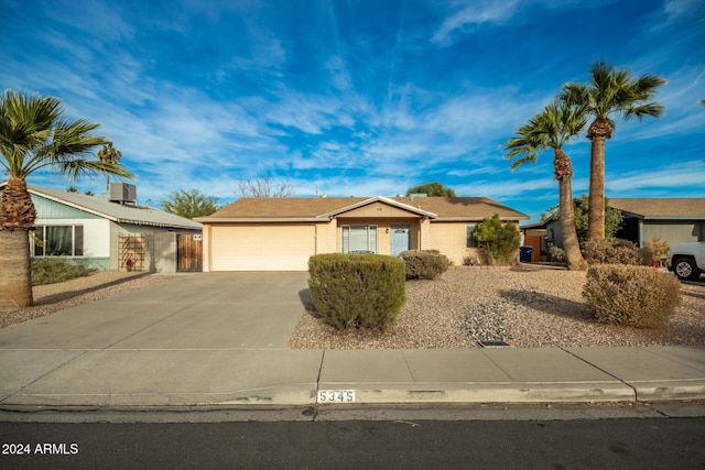 ranch-style home with a garage and cooling unit