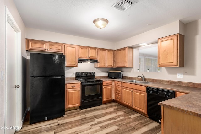 kitchen with sink, light hardwood / wood-style flooring, and black appliances