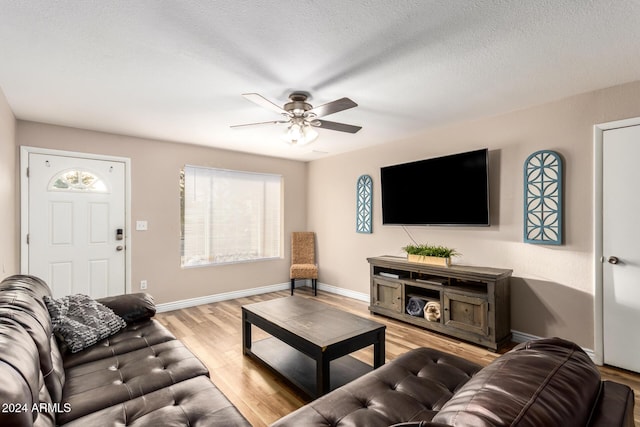 living room with ceiling fan, light hardwood / wood-style flooring, and a textured ceiling