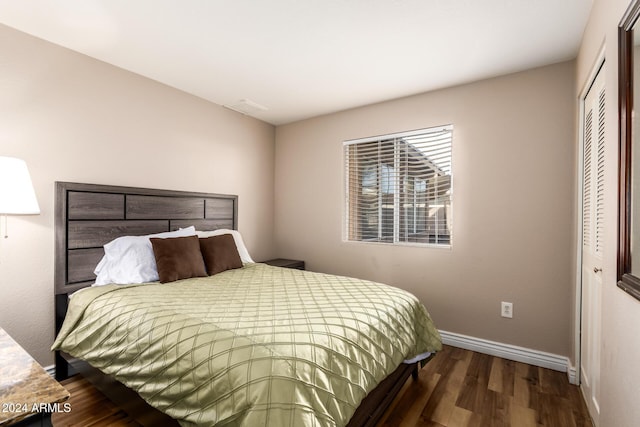 bedroom featuring dark wood-type flooring and a closet