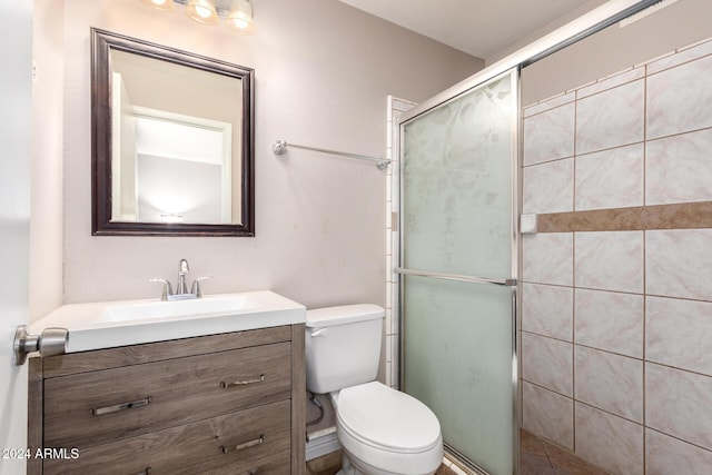 bathroom with vanity, toilet, and a shower with shower door