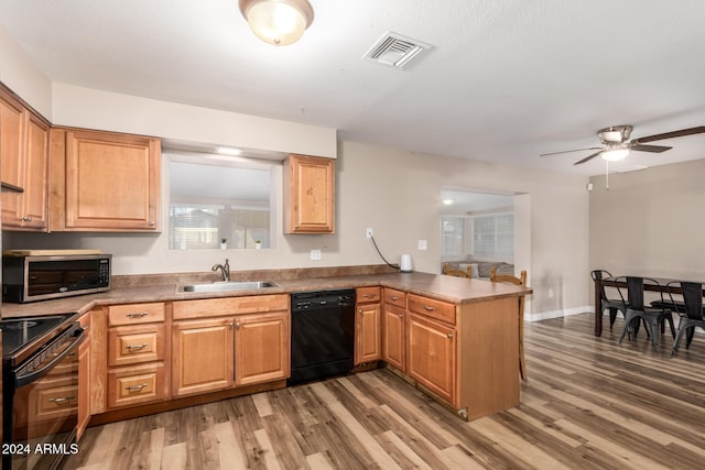 kitchen with ceiling fan, sink, dark hardwood / wood-style flooring, kitchen peninsula, and black appliances