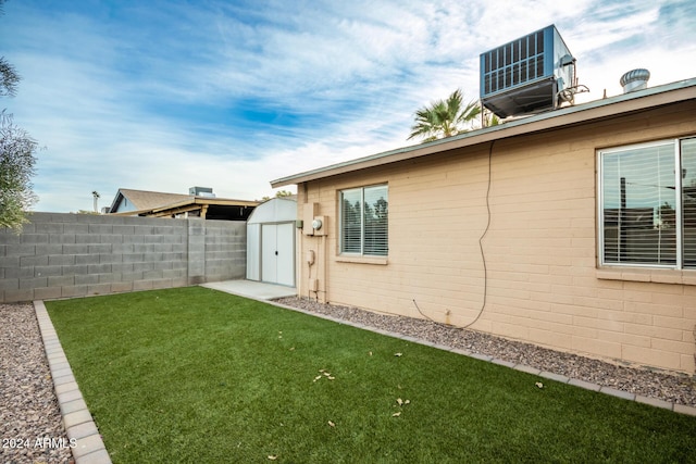 view of yard with central AC unit and a storage unit