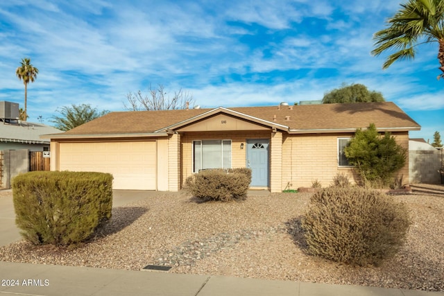 single story home featuring a garage and central air condition unit