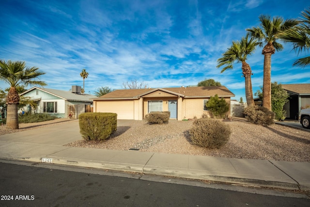 single story home featuring cooling unit and a garage