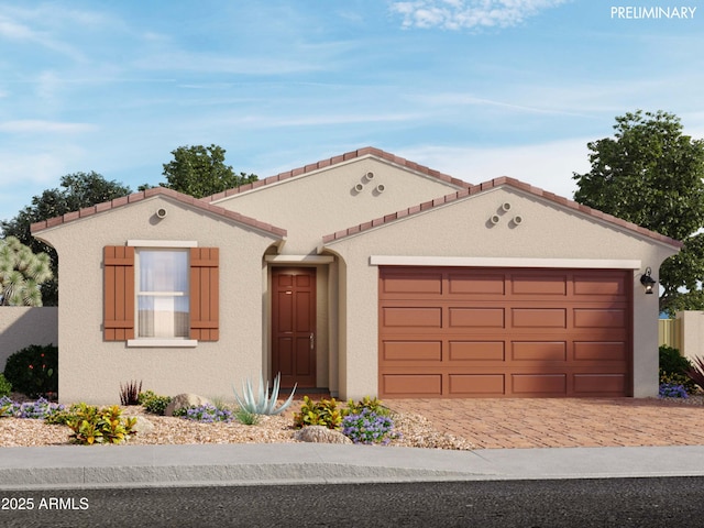 mediterranean / spanish-style house with decorative driveway, an attached garage, and stucco siding