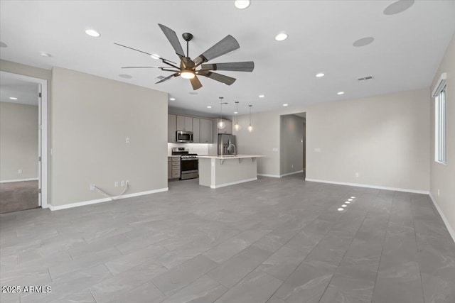 unfurnished living room featuring visible vents, recessed lighting, baseboards, and a ceiling fan