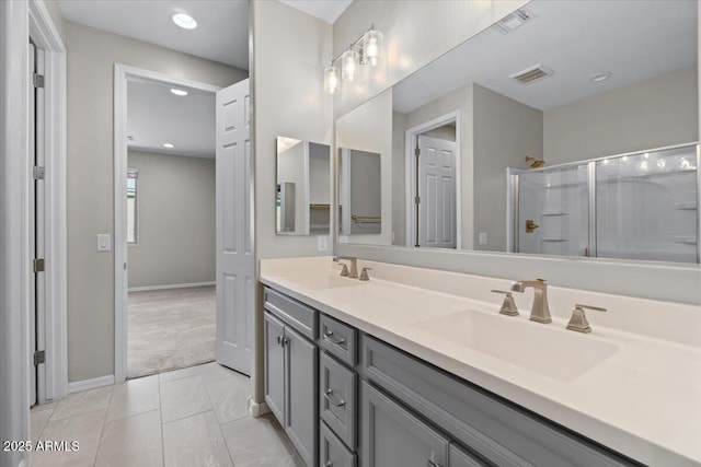 bathroom with an enclosed shower, double vanity, baseboards, and a sink