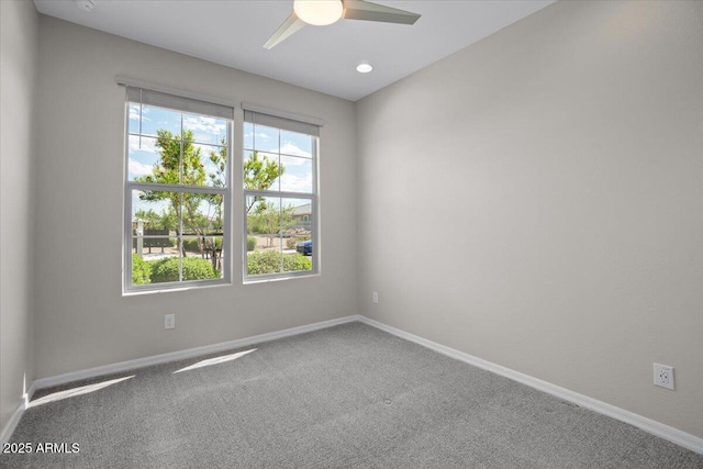 carpeted spare room with baseboards, plenty of natural light, and ceiling fan